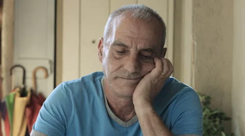 Elder man is sitting alone at the table thinking to his problems: sadness, sad Stock Footage 41757935