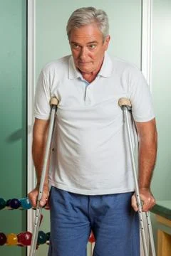 Elder man using a crutches Stock Photos