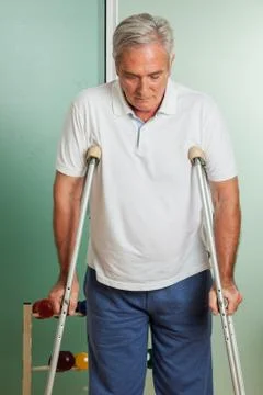 Elder man using a crutches Stock Photos