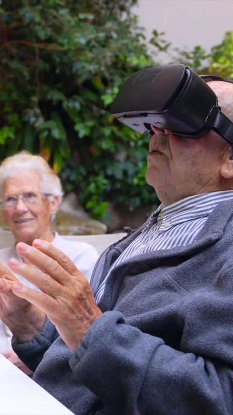 Elder man using virtual reality goggles in a nursing home Stock Footage 256985103