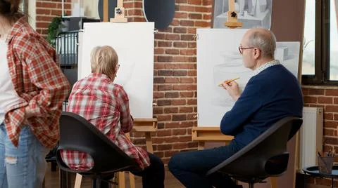 Elder people learning to draw on canvas in art workshop Stock Photos