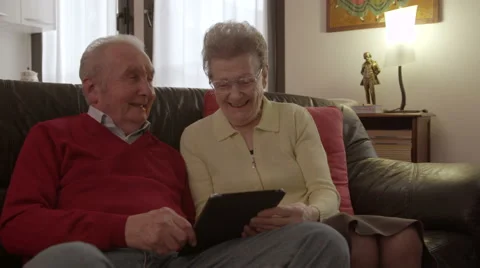 Elder senior couple browsing and watching videos on a tablet Vídeo Stock 44981001