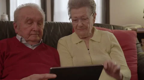 Elder senior couple browsing and watching videos on a tablet Vídeo Stock 44983062