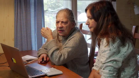 Elder Taught Computer Skills with Mouse Guidance by Younger Woman Indoors. Stock Footage 320325989