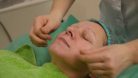 Elder woman getting face massage at beauty salon Stock Footage 102400422