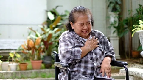 Elder woman patient pain in her heart on wheelchair Stock Footage