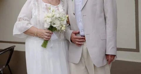 Elderly 70 year old couple stand near the wall in an embrace Stock Footage 229717541