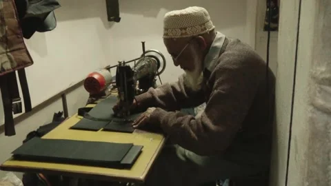 Elderly artisan working on a sewing machine Stock Footage 345896438