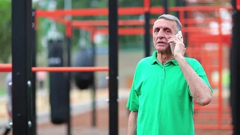 Elderly athlete talks on smartphone Video stock 83845282