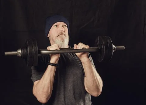 Elderly athletic man getting ready to do a barbell press Stock Photos