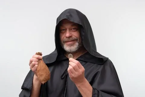 Elderly bearded monk smiling while holding coin isolated on white background. 写真素材