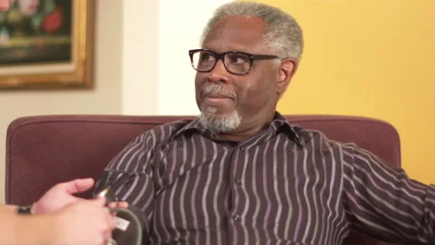Elderly black man gets his blood pressure checked with a test by a nurse Stock Footage 239782187