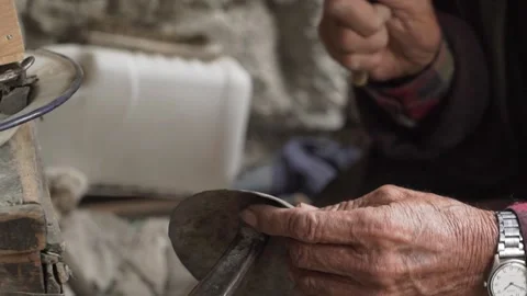 Elderly blacksmith crafts copper using a hammer and anvil in Ladakh, India Video stock 294055282