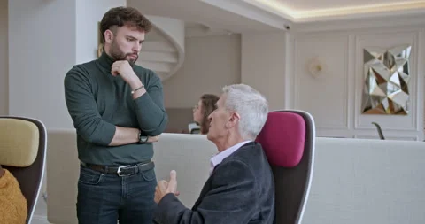 Elderly business person explaining, sharing experience or knowledge to a young 動画素材 273814352