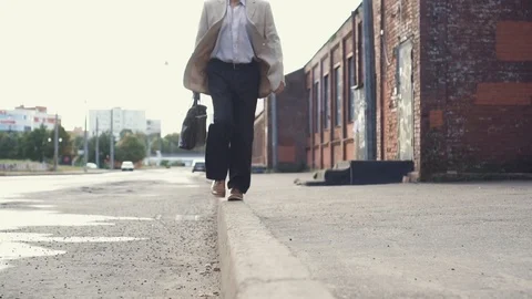 Elderly businessman in a jacket with briefcase have fun, walking on the border Stock Footage 101505821