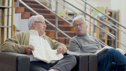 Elderly Caucasian men sitting in library and talking Stock-Footage 232621080