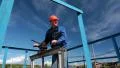 Elderly Caucasian worker in a helmet at the factory with the pipe valve HD Footage