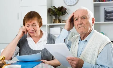 Elderly couple consider contract Stock Photos