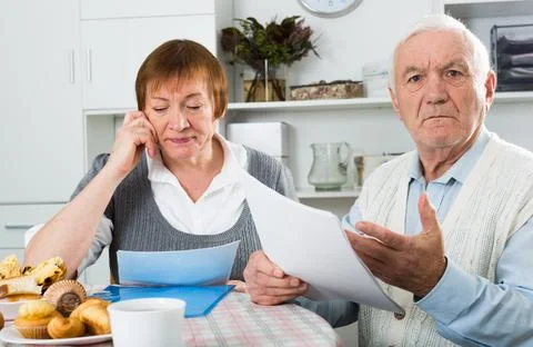 Elderly couple consider contract Stock Photos
