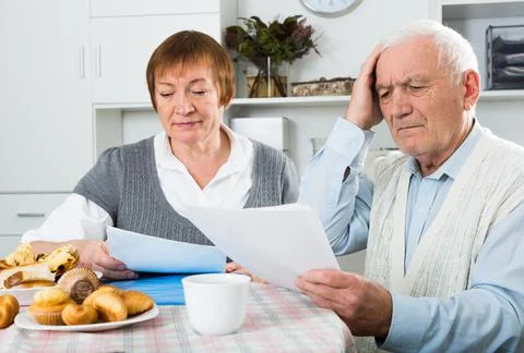 Elderly couple consider contract Stock Photos