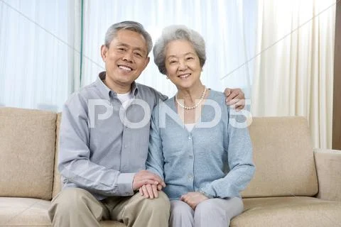 Elderly couple on couch Stock Photos