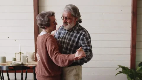 An elderly couple dancing romantically in the kitchen. Pensioners and their Video stock 243731140