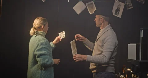 Elderly Couple Developing and Reviewing Black-and-White Photos in a Vintage Stock Footage 305100194