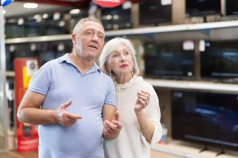 Elderly couple doing shopping inside consumer electronics supermarket Stock Photos