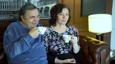 An elderly couple drinks hot tea and laughs. Stock Footage 86684642
