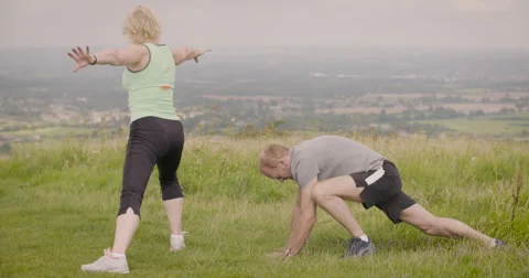Elderly couple exercising in field Stock Footage 59899757