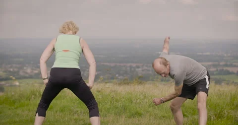 Elderly couple exercising in field Stock Footage 59911779