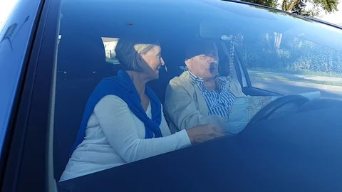 Elderly couple exploring travel map view through windshield Stock Footage 127182287