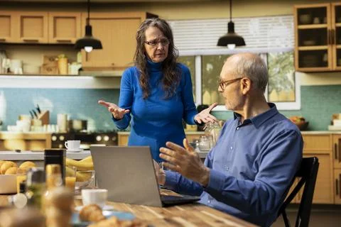 Elderly couple facing difficult quarrel in the kitchen with woman furious Stock Photos