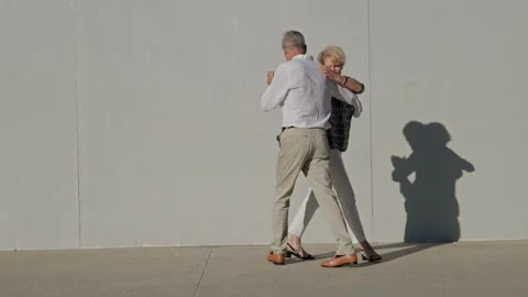 Elderly couple gracefully dancing tango outdoors Stock Footage 309400971