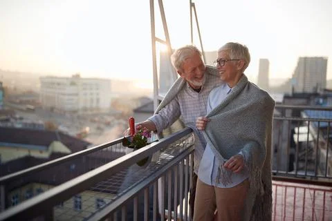 An elderly couple having fun while they enjoying on the terrace of their apar Stock Photos