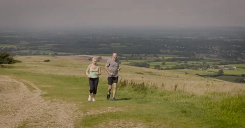 Elderly couple jogging in field Stock-Footage 59899860