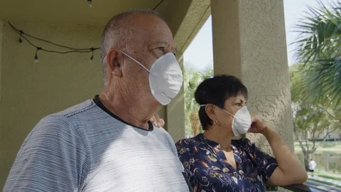 Elderly couple looking at each other wearing face masks during quarantine Stock Footage 127196148