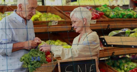 Elderly couple shopping for vegetables with data processing animation overlay Stock Footage 305188906