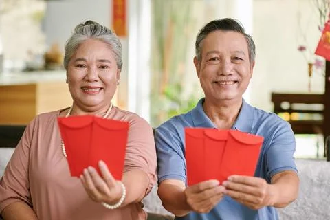 Elderly Couple Showing Red Evelope Stock Photos