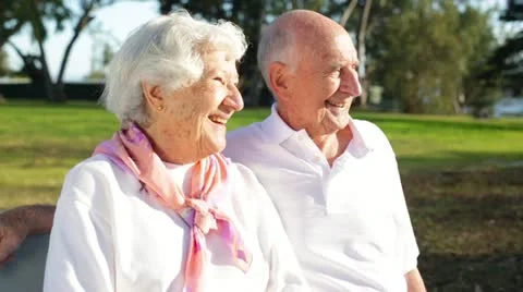 Elderly Couple Sitting on Bench Smiling Enjoying the Day Stock Footage 21923371