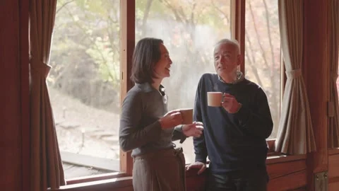 Elderly couple talking and smiling over steaming co Vídeo Stock 336764951