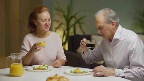 Elderly couple talking cheerfully at breakfast Stock Footage 142340200