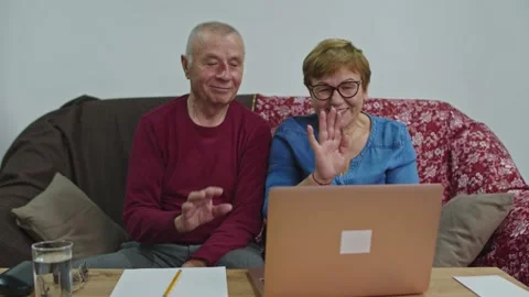 An elderly couple is talking on video while sitting at home. Stock Footage 145279738