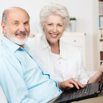 Elderly couple using a laptop computer Stock Photos