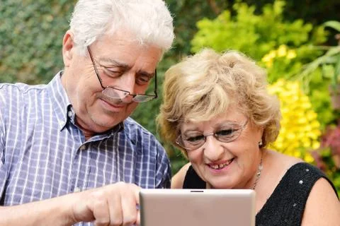 Elderly couple using tablet. Stock Photos