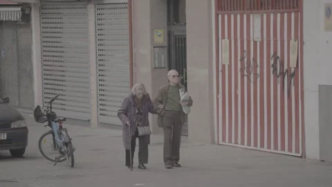 An elderly couple is walking along the side of the road in Madrid, Spain Stock Footage 345027424