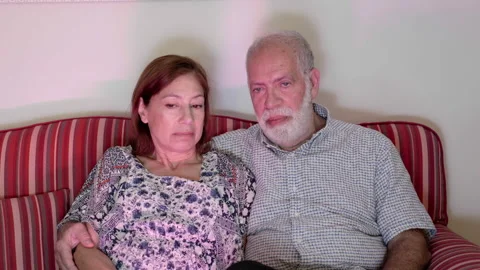Elderly couple watch a boring program with sad faces on TV. Human emotions and Vídeos de archivo 227894225