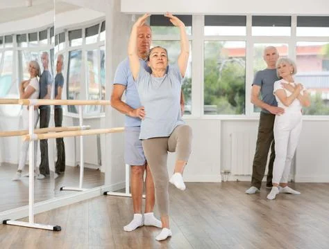 Elderly couples learning to dance ballet in dance studio Stock Photos