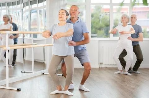 Elderly couples learning to dance ballet in dance studio Stock Photos