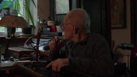 Elderly craftsman working in his old workshop, restoring bladed weapons Stock Footage 328408026